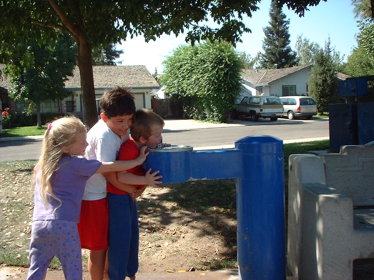 Three kids at drinking fountain [IMG]